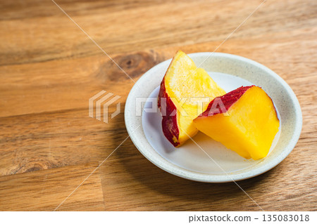Sweet potato simmered in sweet sauce served on a small plate Sweet potato simmered in sweet sauce served on a small plate 135083018