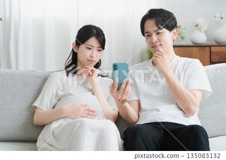 孕婦和丈夫操作智慧型手機生活風格影像 135083132