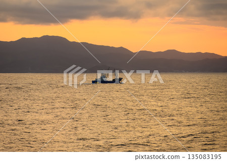 Fishing boat sailing on the sea at dusk Fishing boat sailing on the sea at dusk 135083195