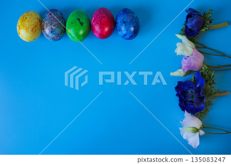 Beautiful spring flowers and easter eggs put in frame on blue background. Beautiful spring flowers and easter eggs put in frame on blue background. 135083247