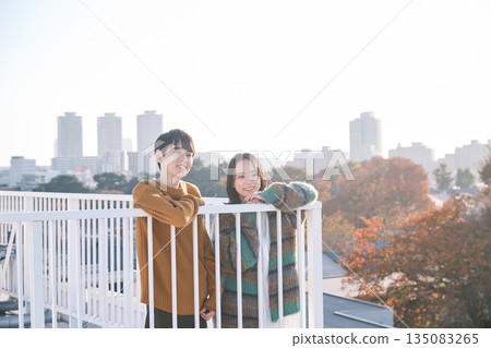 一對情侶在屋頂上向外眺望 一對情侶在屋頂上向外眺望 135083265