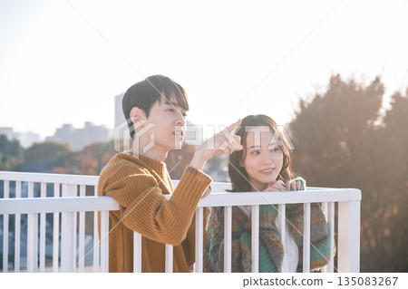 一對情侶在屋頂上向外眺望 一對情侶在屋頂上向外眺望 135083267