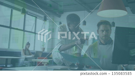Leaning Black worker pointing at computer screen while manager reviewing folder in modern office 135083585