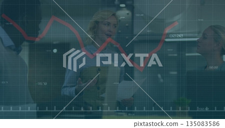 Three professionals wearing business attire discussing data in office, with red line graph  and  rep 135083586