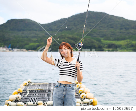 A woman fishing in the sea (Photo courtesy of Oki Seaside Resort Miyabi) A woman fishing in the sea (Photo courtesy of Oki Seaside Resort Miyabi) 135083697