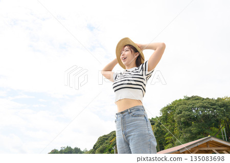 A woman wearing a straw hat looks up at the blue sky. (Photo courtesy of Oki Seaside Resort Miyabi) A woman wearing a straw hat looks up at the blue sky. (Photo courtesy of Oki Seaside Resort Miyabi) 135083698
