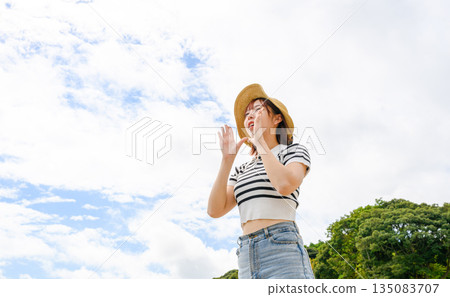 A woman screaming under the blue sky [Photography cooperation: Oki Seaside Resort Miyabi] 135083707