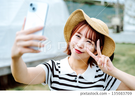 Selfie with a straw hat and peace sign [Photography cooperation: Oki Seaside Resort Miyabi] 135083709