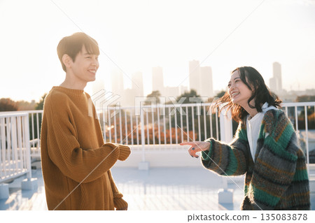 黃昏時分，一對情侶在屋頂上。 135083878