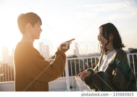 黃昏時分，一對情侶在屋頂上。 135083925