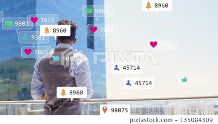 Standing on balcony, man with image of social media notifications over cityscape Standing on balcony, man with image of social media notifications over cityscape 135084309