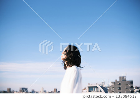 Young woman standing on the roof 135084512