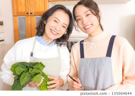 Daughter learning cooking from mother 135084644