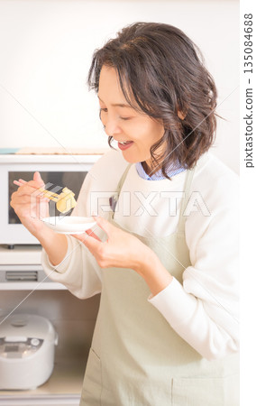 Middle-aged woman tasting Middle-aged woman tasting 135084688
