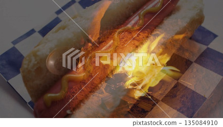 Featuring hotdog with mustard line on blue white checkered paper at food stall table with flame Featuring hotdog with mustard line on blue white checkered paper at food stall table with flame 135084910