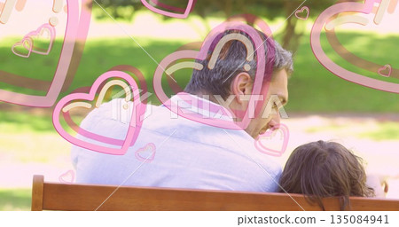 Sitting father and son sharing moment on wooden park bench, with translucent pink heart graphics Sitting father and son sharing moment on wooden park bench, with translucent pink heart graphics 135084941