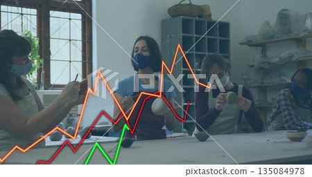 Crafting group of four aproned, masked adults shaping pottery on table, with supply shelves Crafting group of four aproned, masked adults shaping pottery on table, with supply shelves 135084978