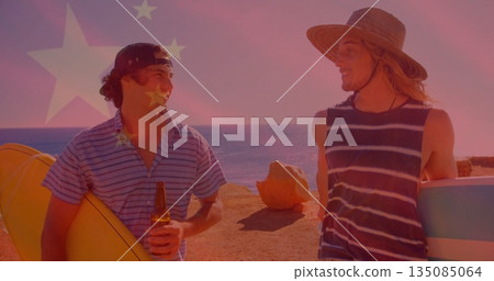 Chatting surfers wearing straw hat and baseball cap on rocky shoreline, holding surfboards, beer Chatting surfers wearing straw hat and baseball cap on rocky shoreline, holding surfboards, beer 135085064