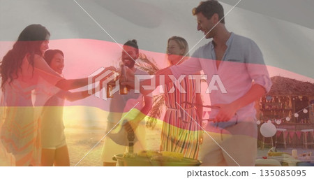 Raising bottles five friends wearing summer clothing gathering around grill on beach with tiki bar Raising bottles five friends wearing summer clothing gathering around grill on beach with tiki bar 135085095