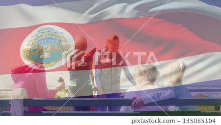Group of five women socializing in athletic wear on waterfront promenade, with shaker bottle Group of five women socializing in athletic wear on waterfront promenade, with shaker bottle 135085104