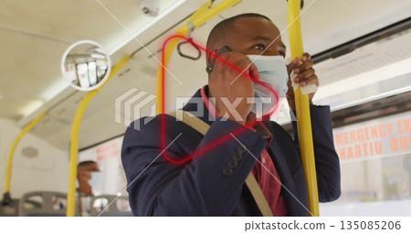 Standing man talking on smartphone and holding yellow handrail inside bus with emergency exit sign Standing man talking on smartphone and holding yellow handrail inside bus with emergency exit sign 135085206