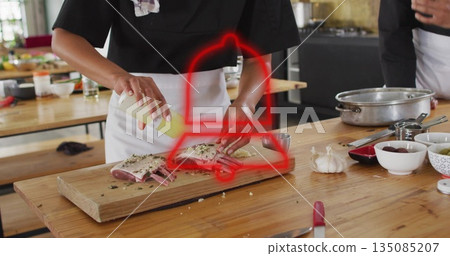 Chef in white apron drizzling sauce onto lamb rack on table in kitchen using squeeze bottle Chef in white apron drizzling sauce onto lamb rack on table in kitchen using squeeze bottle 135085207
