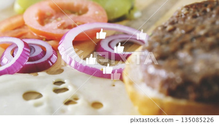 Showing board with melted cheese onion rings in kitchen, tomato pickle patty bun, thumbs-up icons 135085226