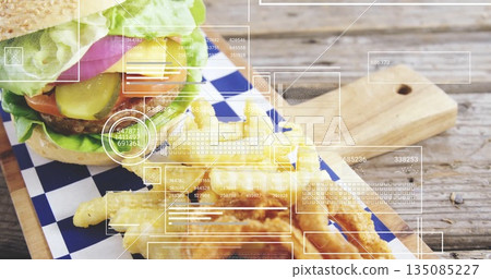 Displaying lettuce-topped burger with fries on checkered wax paper on tabletop, with data overlays Displaying lettuce-topped burger with fries on checkered wax paper on tabletop, with data overlays 135085227
