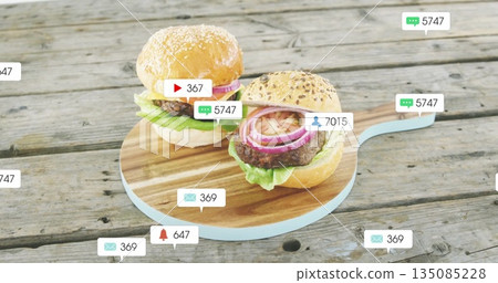 Showing two cheeseburgers resting on wooden board at rustic table, with floating notification icons Showing two cheeseburgers resting on wooden board at rustic table, with floating notification icons 135085228