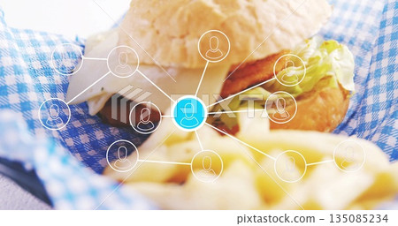 Showing burger sandwich resting on checkered liner in cafe, with cheese, fries and network graphic Showing burger sandwich resting on checkered liner in cafe, with cheese, fries and network graphic 135085234
