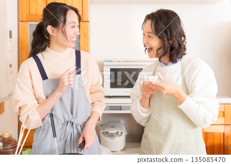 一位母親品嚐女兒做的肉和馬鈴薯燉菜。 135085470