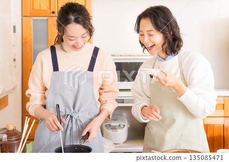 一位母親品嚐女兒做的肉和馬鈴薯燉菜。 一位母親品嚐女兒做的肉和馬鈴薯燉菜。 135085471