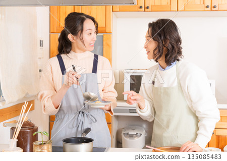 一位母親品嚐女兒做的肉和馬鈴薯燉菜。 135085483