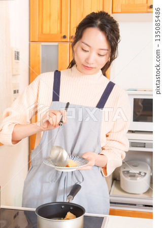 A young woman serving meat and potatoes on a plate 135085486
