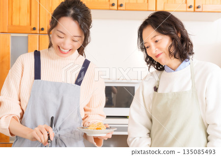 一位母親品嚐女兒做的肉和馬鈴薯燉菜。 135085493