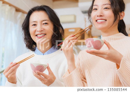 Mother and daughter smiling and saying it's delicious Mother and daughter smiling and saying it's delicious 135085544