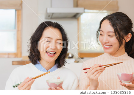Mother and daughter smiling and saying it's delicious 135085556