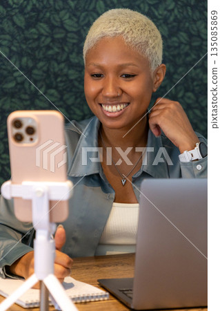 African American woman smiles at camera of her phone. female blogger records video. 135085869