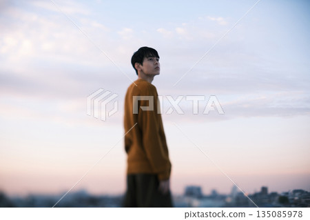 A man gazing into the distance at dusk 135085978