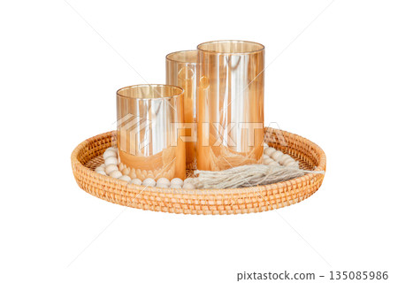 A bunch of candles in dark glass bottles on a beautiful wicker tray. Soft focus. Photo on white background. Isolated object. 135085986