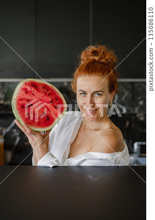 Smiling girl holding a fresh watermelon, enjoying summer vibes with juicy fruit. Smiling girl holding a fresh watermelon, enjoying summer vibes with juicy fruit. 135086110