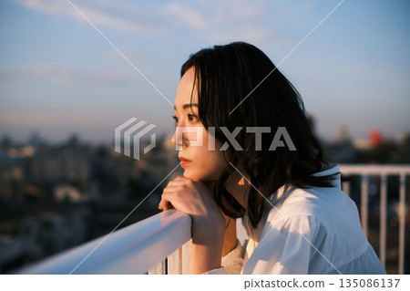 Portrait of a woman on a rooftop at dusk 135086137