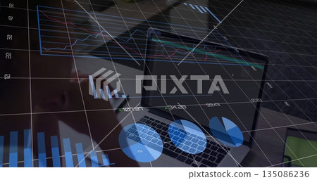 Holding stylus, businesswoman analyzing charts on business laptop at office desk, with smartphone Holding stylus, businesswoman analyzing charts on business laptop at office desk, with smartphone 135086236