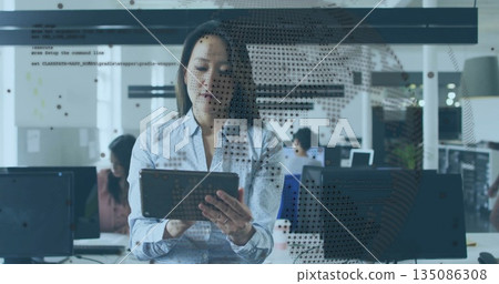 Standing Asian project manager holding tablet in open plan office, with world map and code overlay Standing Asian project manager holding tablet in open plan office, with world map and code overlay 135086308