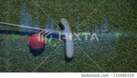Sitting red golf ball and silver putter head on putting green, with translucent equalizer graphic 135086359