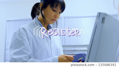 Adult Asian lab technician entering data in laboratory room, with clipboard monitor and stethoscope Adult Asian lab technician entering data in laboratory room, with clipboard monitor and stethoscope 135086391