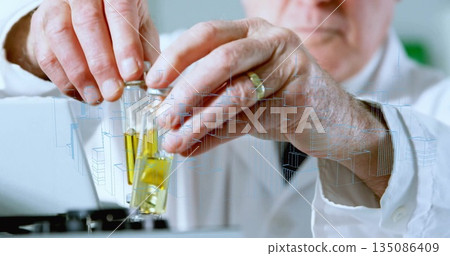 Aligning yellow vials, senior scientist in lab coat at lab bench, with test tube rack 135086409