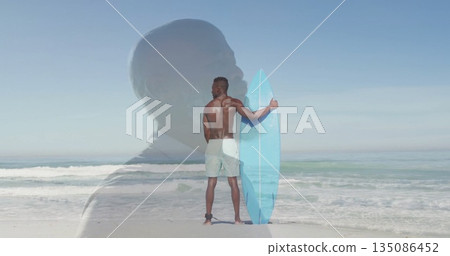 Holding light blue surfboard, surfer wearing green boardshorts on ocean shore, with suit silhouette 135086452