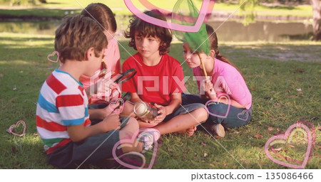 Examining children using magnifying glass inspecting jar by pond at park with insect net and hearts 135086466