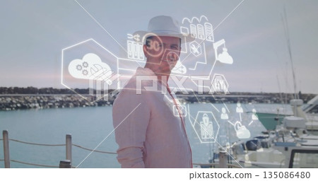 Standing man wearing linen shirt and white fedora hat on marina pier, with floating interface icons Standing man wearing linen shirt and white fedora hat on marina pier, with floating interface icons 135086480